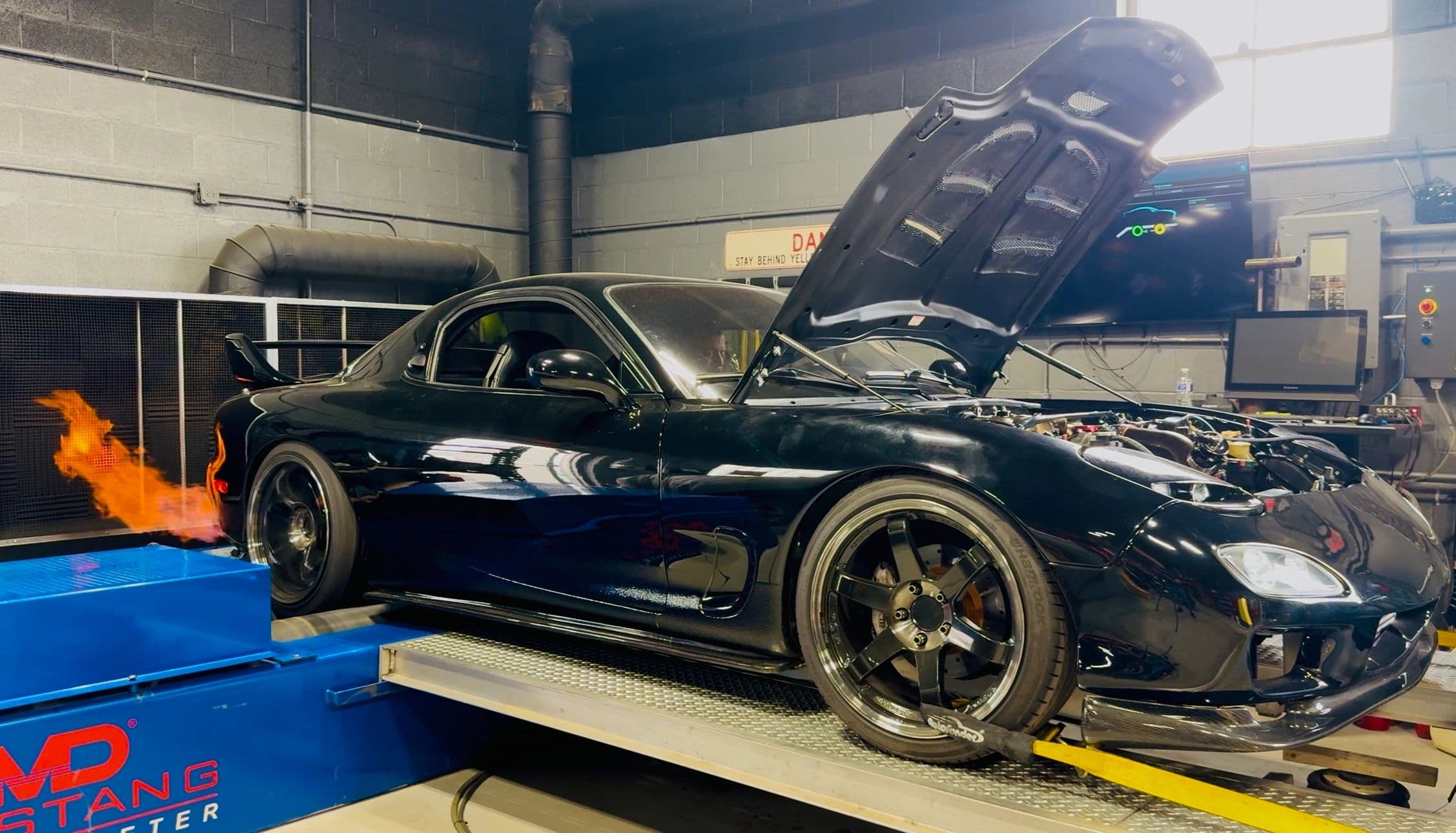 Black FD3S RX-7 strapped to the chassis dyno with exhaust flame
