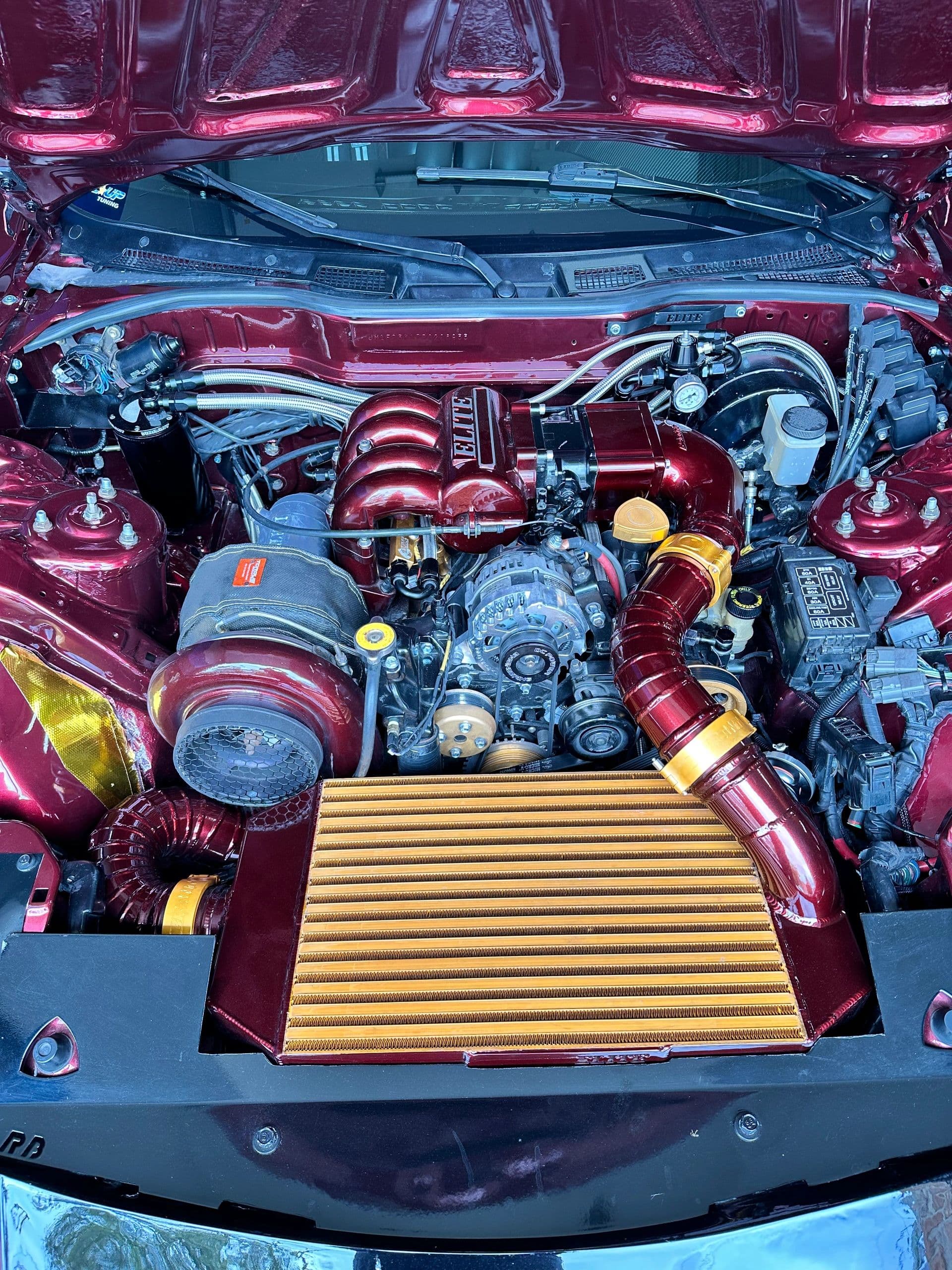 Single-turbo FD3S RX-7 engine bay with colour-matched piping